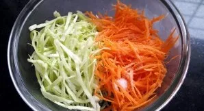 Kopūstus ir morkas supjaustykite juostelėmis, sudėkite į vieną indą ir įberkite druskos.