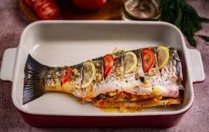 Tada žuvies pilvą sandariai pripildykite kepintais svogūnais ir morkomis, suberkite smulkiai supjaustytus krapus (krapus galite iš anksto...