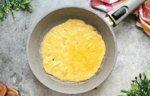 Įkaitinkite keptuvę ant vidutinės ugnies, patepkite ją augaliniu aliejumi ir supilkite 1/3 kiaušinių mišinio. Apkepkite blyną iš abiejų p...