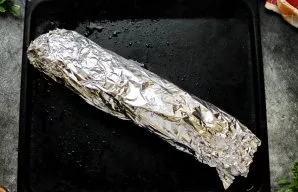 Vyniotinį suvyniokite į kepimo popierių, o tada į kepimo foliją.