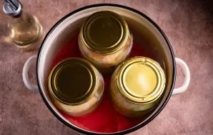 Uždenkite stiklainius dangteliais ir sudėkite juos į didelį puodą, pripildytą vandens (gera idėja pirmiausia dugną iškloti virtuviniu ran...