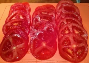 Kol mėsa marinuojasi prieskoniuose, susmulkinkite likusius ingredientus. Pomidorus supjaustykite žiedais.