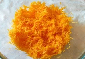 Moliūgo minkštimą sutarkuokite smulkia tarka ir sudėkite į gilų dubenį.