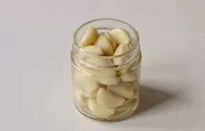Česnaką sudėkite į švarų, sterilizuotą stiklainį.