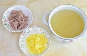 Užvirinkite sultinį. Sudėkite mėsą ir kubeliais pjaustytas bulves. Troškinkite 10–15 minučių.