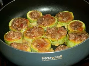 Cukinijų žiedus apkepkite augaliniame aliejuje. Po 3–5 minučių (kai cukinijų kraštai paruduos) sudėkite paruoštą įdarą.