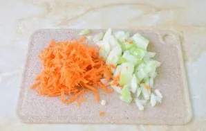 Tuo tarpu nulupkite svogūną ir morką. Morką sutarkuokite, o svogūną smulkiai supjaustykite.