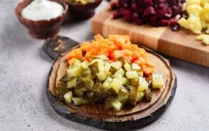 Taip pat supjaustykite morkas ir marinuotus agurkus mažais kubeliais.