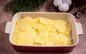 Kepimo indo dugną sutepkite augaliniu aliejumi ir sluoksniu išdėliokite pusę bulvių griežinėlių, įberkite šiek tiek druskos (1/2 arbatini...