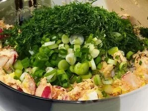 Į salotas įdėkite ridikėlius, taip pat smulkiai supjaustytus svogūnų laiškus ir krapus.