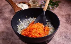 Tada į keptus svogūnus sudėkite morkas.