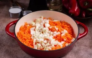 Į didelę keptuvę įpilkite augalinio aliejaus ir sudėkite svogūną bei morką. Kepkite ant vidutinės ugnies, reguliariai maišydami mentele, ...