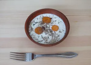 Atskirai kiaušinius išplakite šakute su pienu, druska ir pipirais.