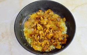 Tada į keptuvę sudėkite voveraites. Viską kartu kepkite dar 2–3 minutes, kol iš grybų išgaruos skystis.