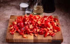 Iš paprikų išimkite sėklas ir nuplaukite jas tekančiu vandeniu. Paprikos minkštimą supjaustykite mažais kubeliais.