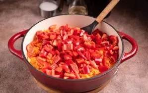 Į keptuvę su svogūnais ir morkomis sudėkite pjaustytą papriką.