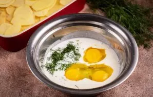 Atskirame dubenyje išplakite kiaušinius, supilkite natūralų jogurtą ir suberkite smulkiai supjaustytus krapus.