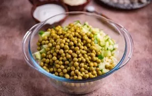 Į dubenį su kitomis daržovėmis sudėkite supjaustytus agurkus ir kiaušinius. Taip pat sudėkite žirnelius.