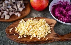 Išvirtus kiaušinius atvėsinkite, nulupkite ir smulkiai supjaustykite arba sutarkuokite smulkia tarka.